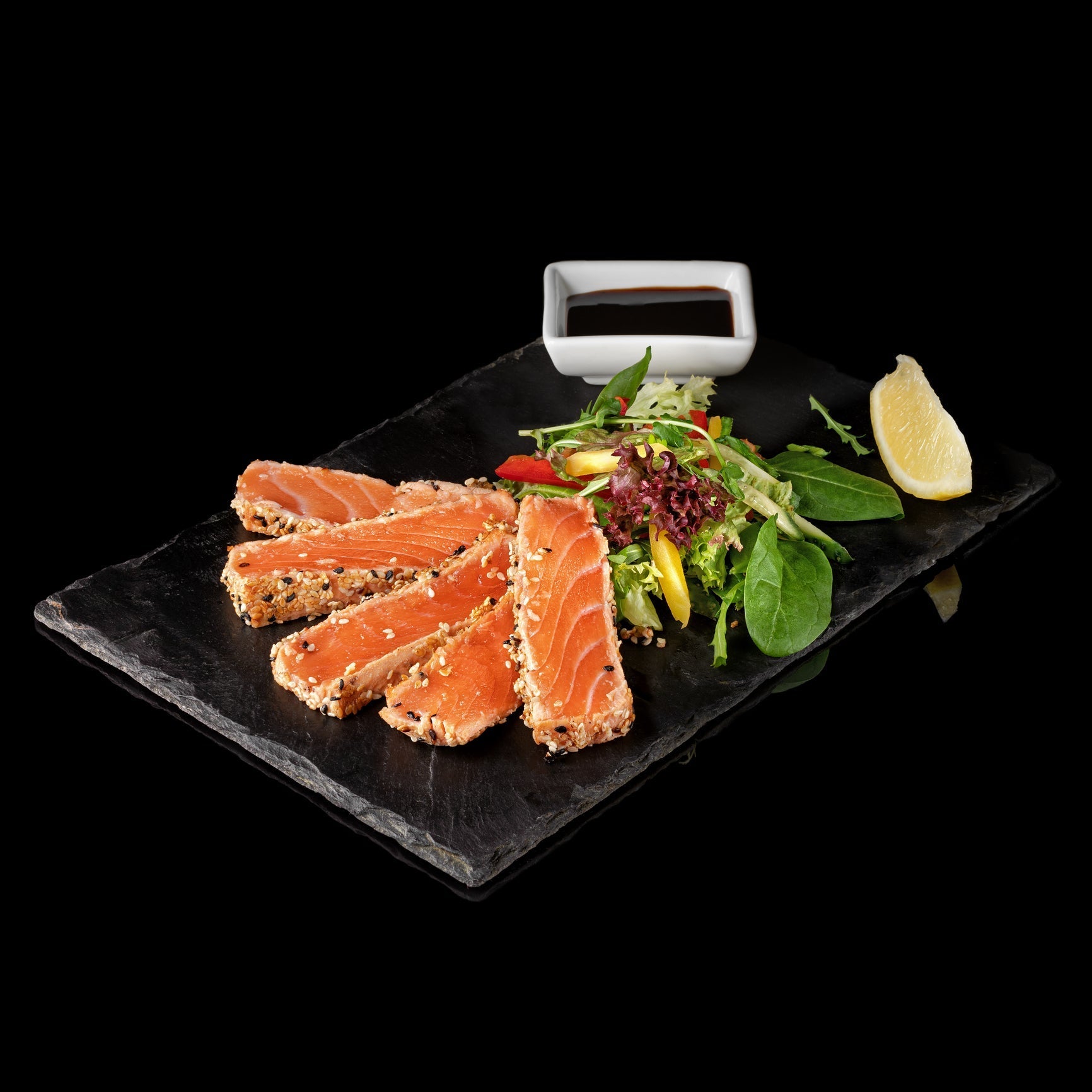 Ora King salmon fillet with rich orange-red marbled flesh on a wooden board surrounded by fresh herbs, lemon, and olive oil in a New Zealand coastal setting