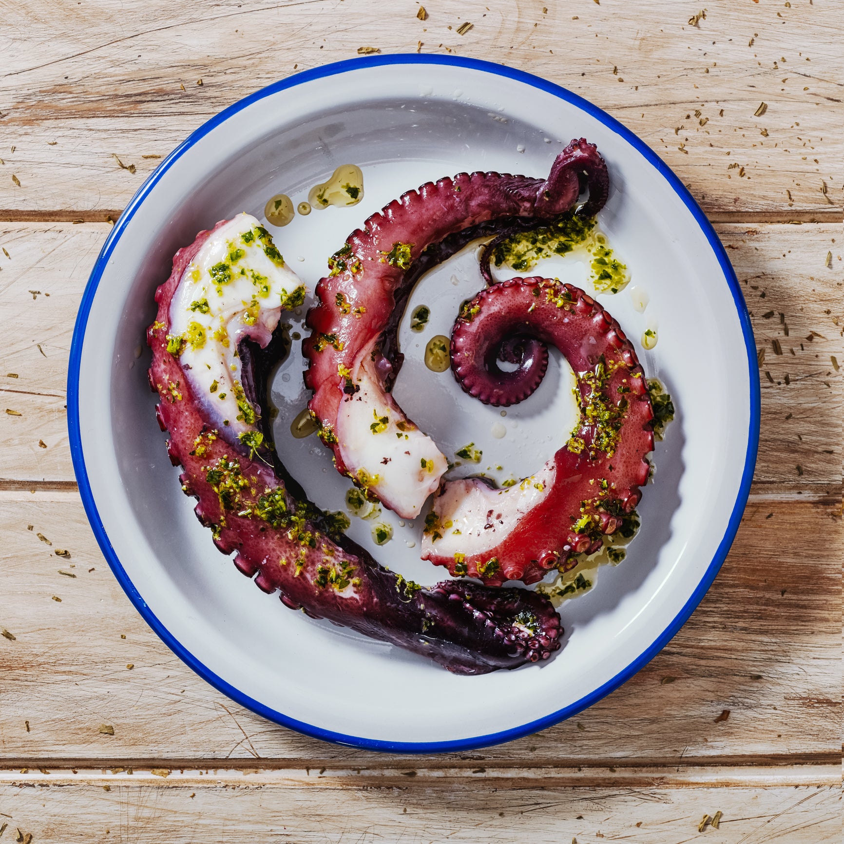 A freshly prepared grilled octopus dish, beautifully presented with charred tentacles and garnished with lemon slices and herbs, showcasing the delicious result of properly cooked seafood