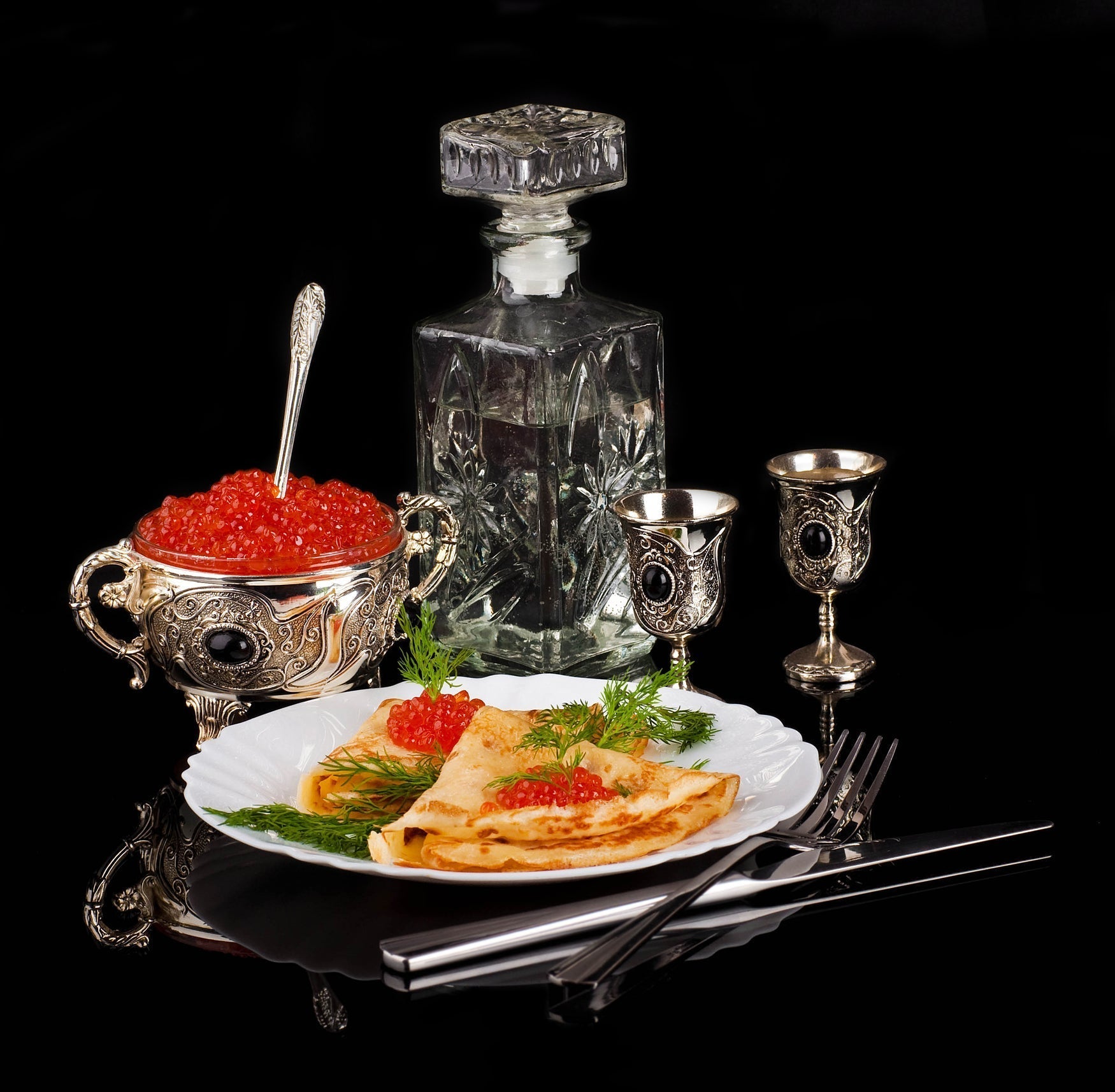 A mother-of-pearl spoon with Kaluga caviar alongside a chilled shot of vodka — the classic pairing that has defined the caviar experience for centuries