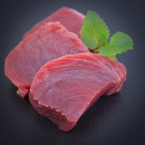 Fresh, vibrant red tuna steak displayed on a clean surface
