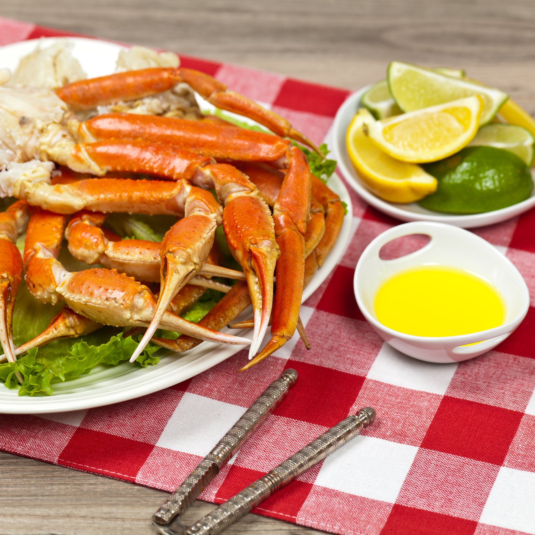 A plate of delicious crab legs with a small bowl of dipping sauce on the side