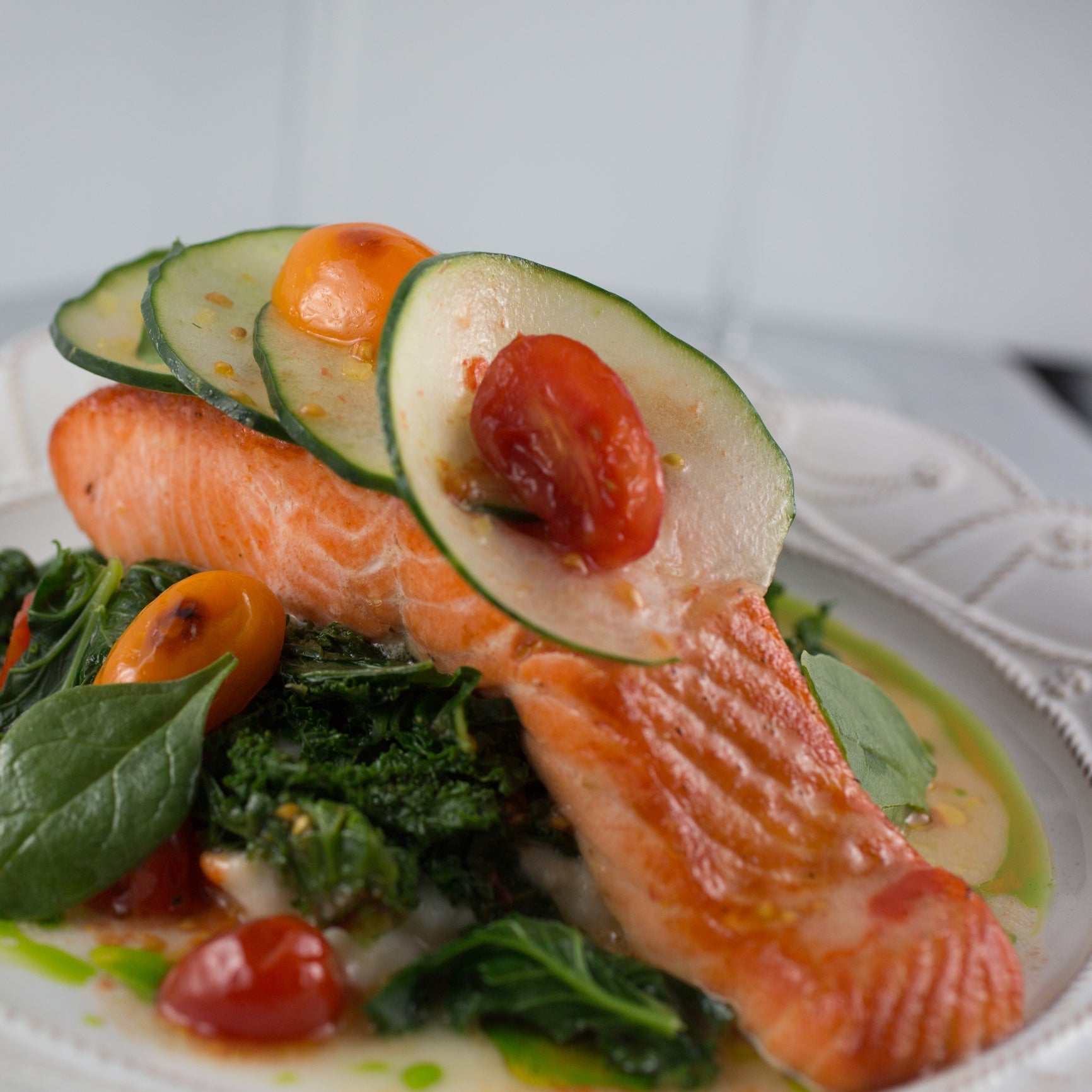 Side-by-side comparison of Ora King salmon fillet and wild-caught Alaskan King Salmon fillet showing color and marbling differences