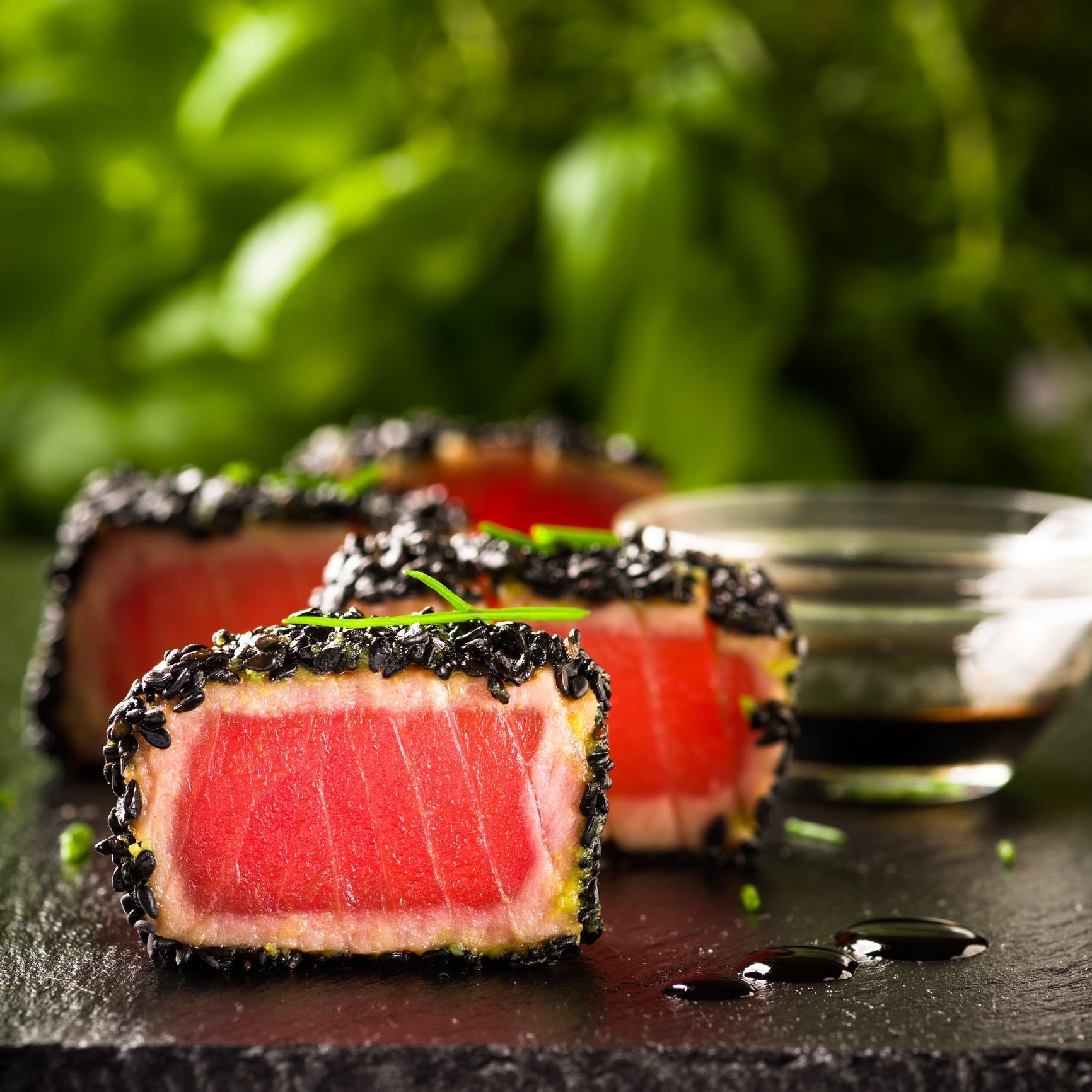 Seared Ahi tuna sliced over spaghetti with cherry tomatoes, Kalamata olives, capers, and fresh basil