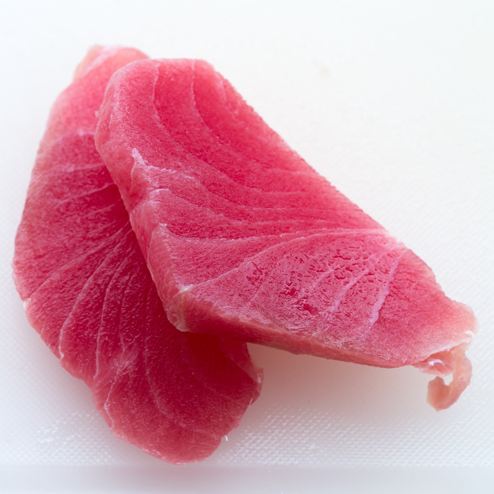 Seared Ahi Tuna steak sliced and plated with sesame seeds, green onions, and mixed greens