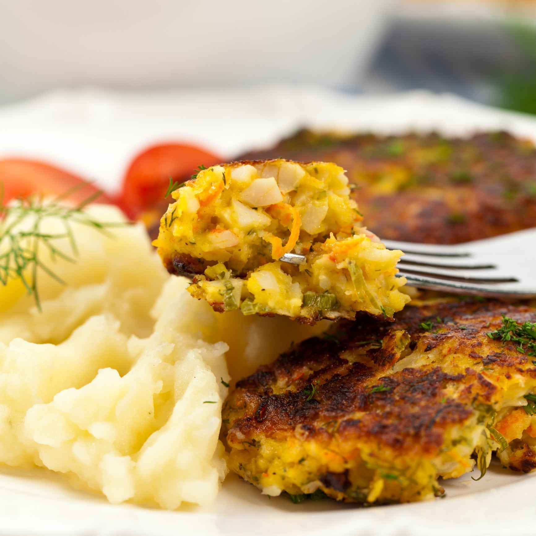 Homemade Dungeness crab cakes golden brown in a skillet, served with lemon and dipping sauce