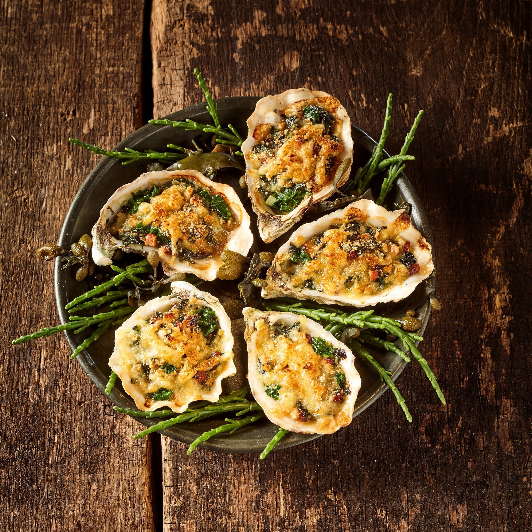 Assorted oyster dishes including Rockefeller, grilled, fried, baked Parmesan, and raw on the half shell
