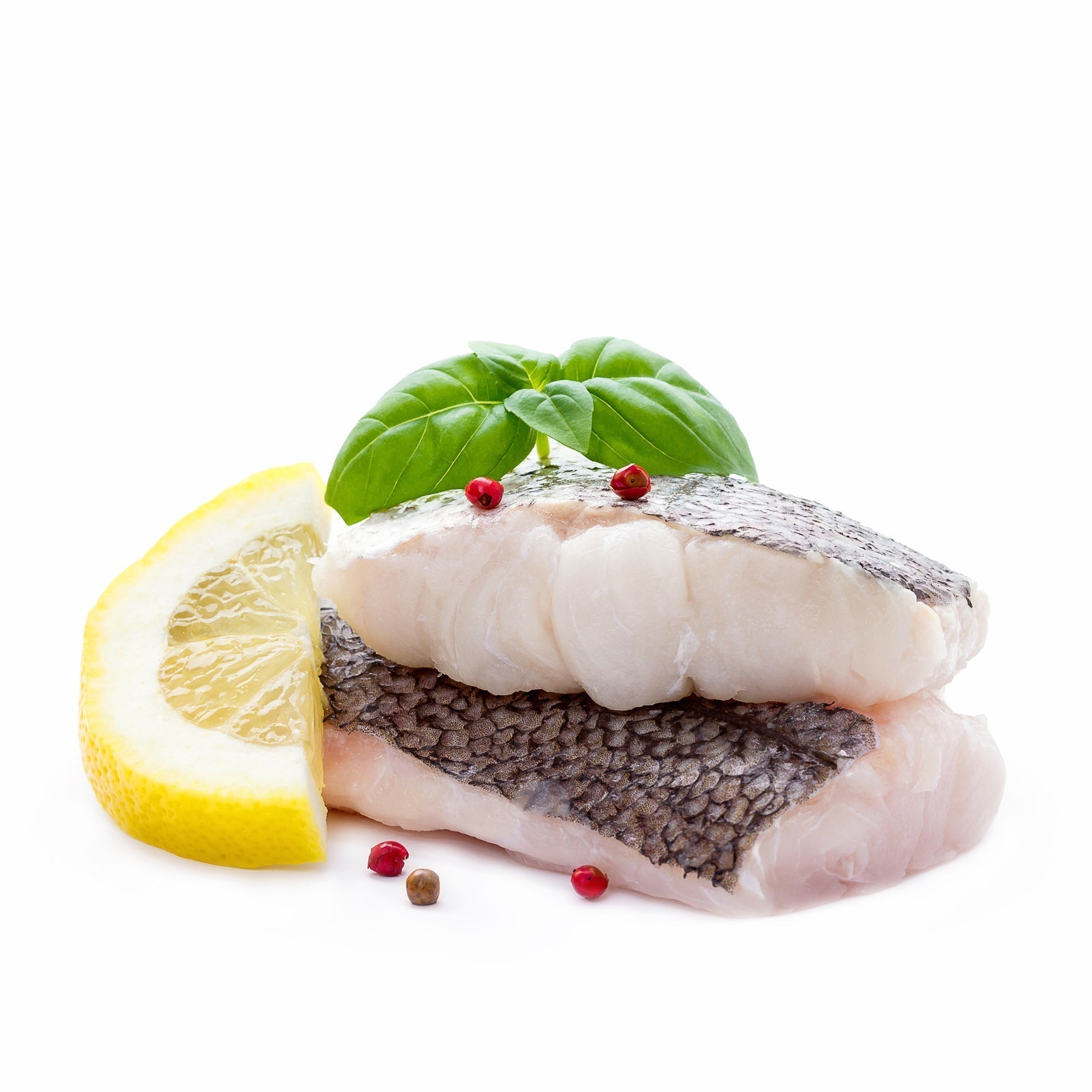 Grilled Pacific Whiting fillet on a plate with lemon slices and fresh herbs, showing its flaky white texture