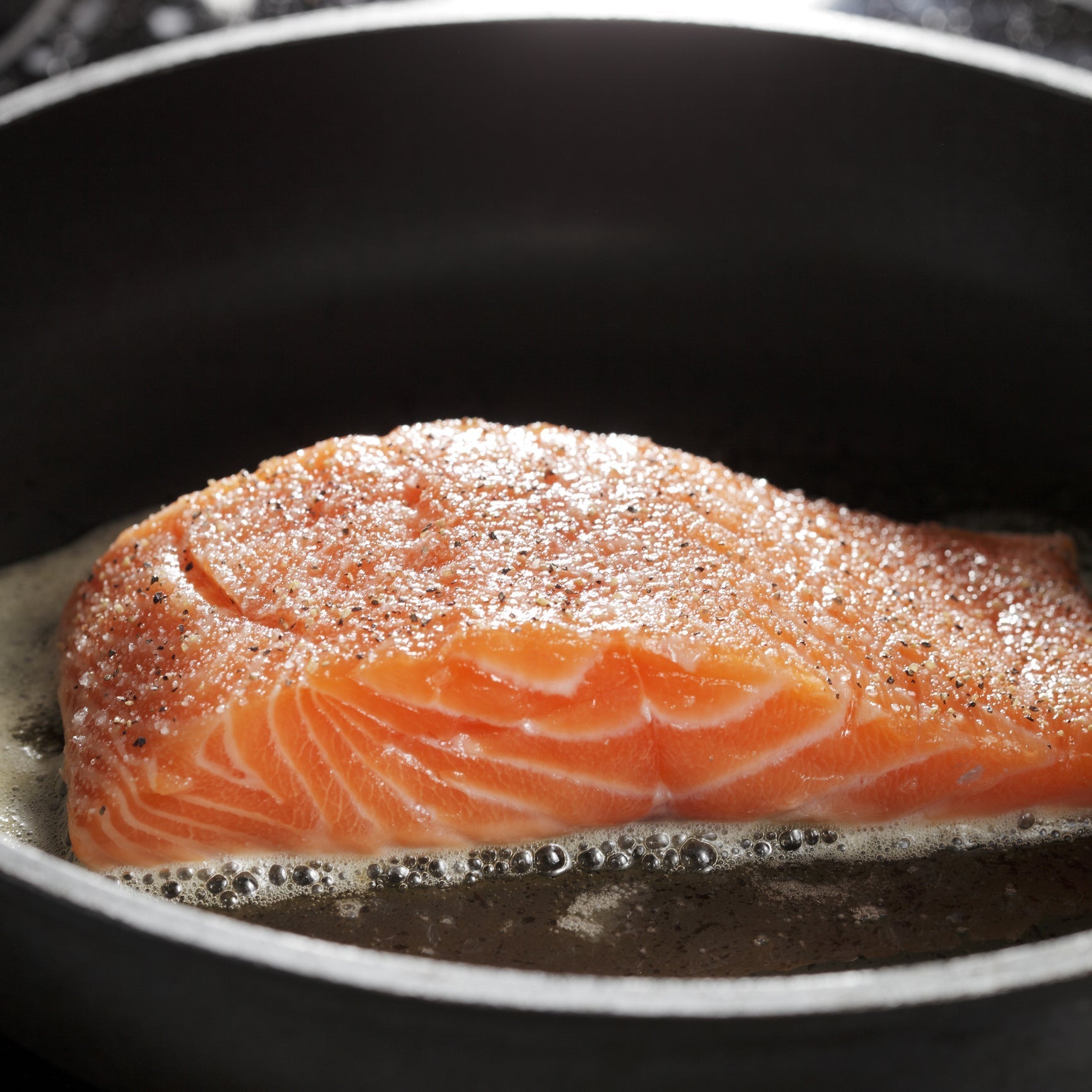 Assorted fresh salmon cuts including sockeye, king, and coho on ice, showcasing vibrant colors and freshness