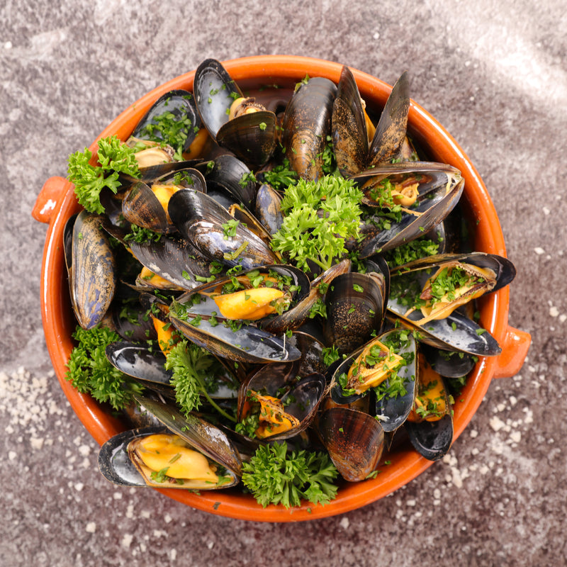 Fresh mussels in a white wine and garlic broth with parsley and crusty bread