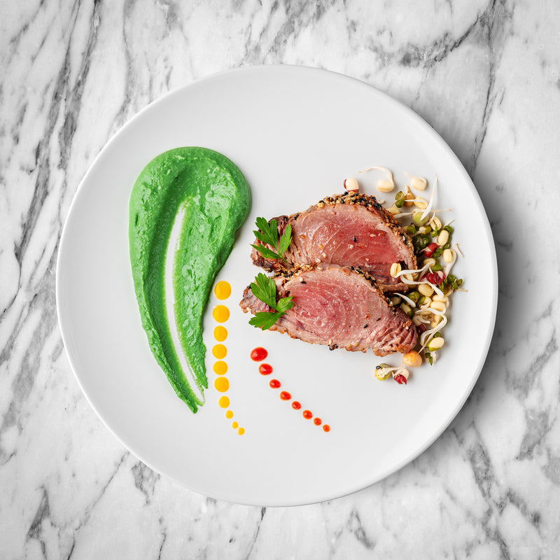 Sliced smoked tuna fillet showing its rich color and firm texture on a wooden board