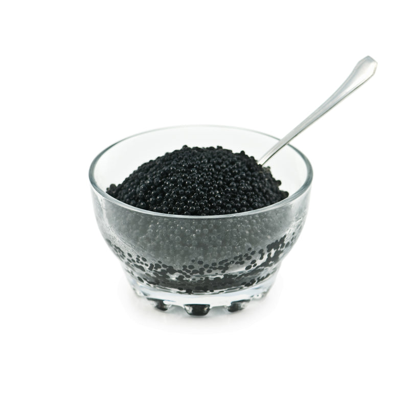 Paddlefish caviar served on blini with crème fraîche and fresh dill on an elegant platter
