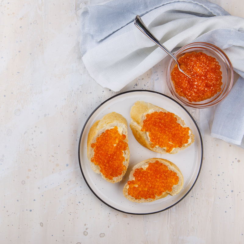 Close-up of fresh ikura salmon roe in a ceramic bowl