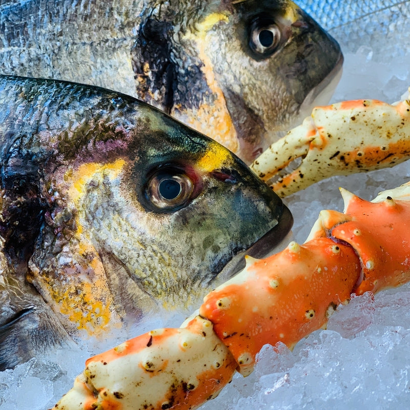 Fresh Alaskan King Crab legs on ice during peak harvest season