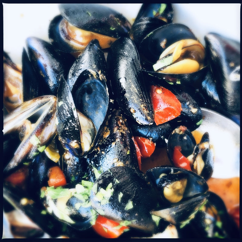 Mussels prepared in different global styles including French moules marinières and Thai coconut curry