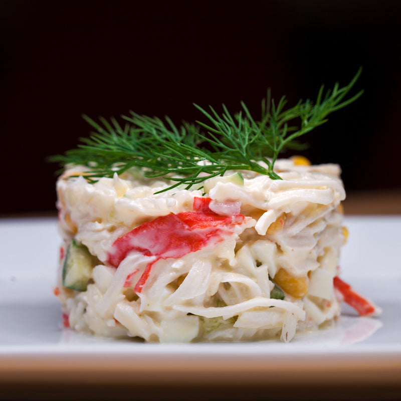 Fresh crab salad with avocado, grapefruit segments, and citrus vinaigrette on a white plate