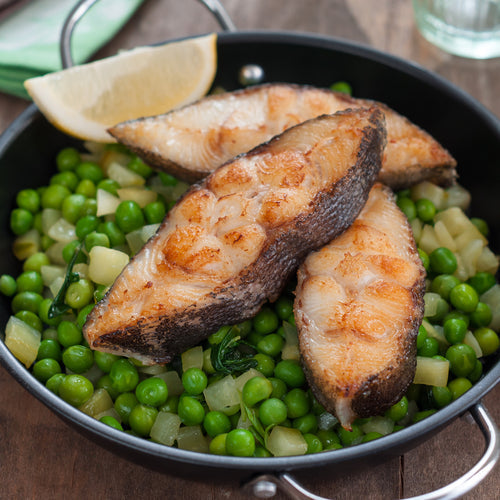 A beautifully plated piece of seared salmon alongside roasted asparagus and lemon butter sauce — one of the classic fish and side dish pairings that works because the acidity of the lemon cuts through the fat of the salmon