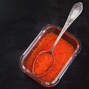 Red caviar in a bowl with crackers