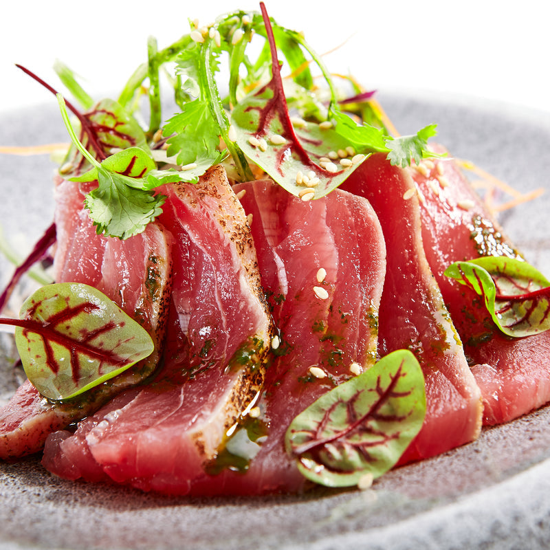 Family sitting together enjoying a smoked tuna dinner at the dining table