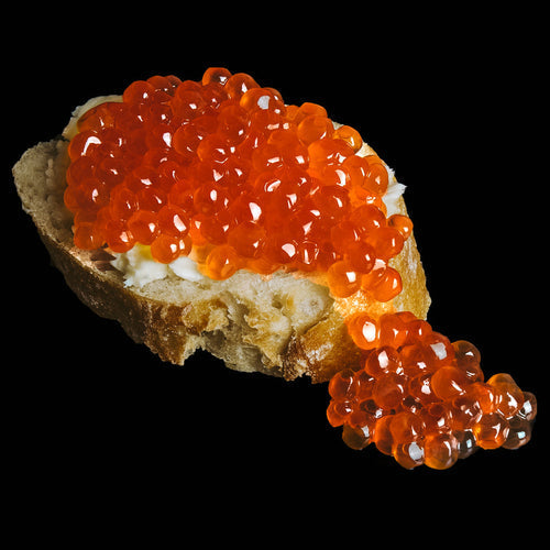 Bright orange Coho salmon roe eggs glistening in a bowl, freshly harvested from Washington State tribal fisheries