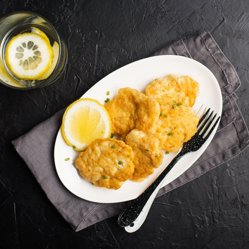 Golden pan-seared live king crab cakes served with lemon wedges and tartar sauce