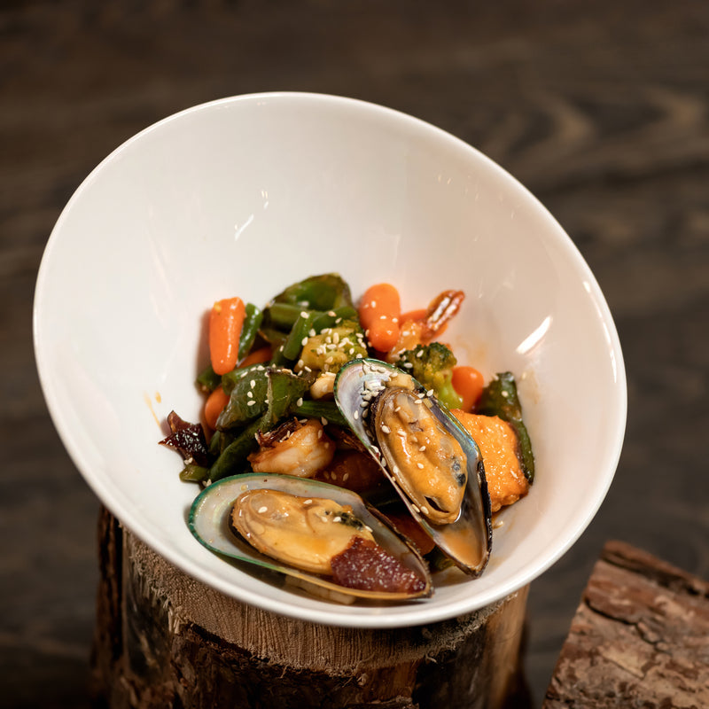 Mussels being steamed in a pot with white wine, garlic, and fresh herbs