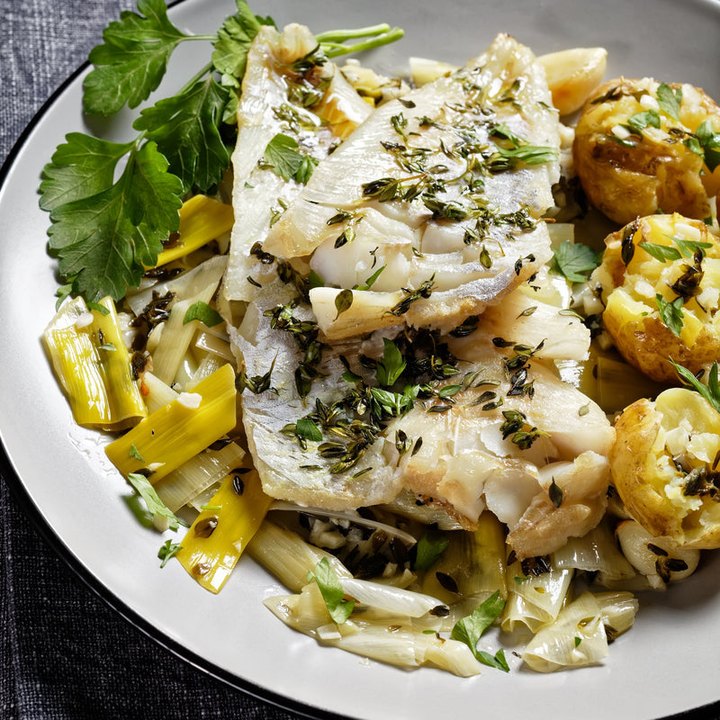 Pan-seared lingcod fillet with lemon butter sauce, roasted asparagus, and a glass of white wine