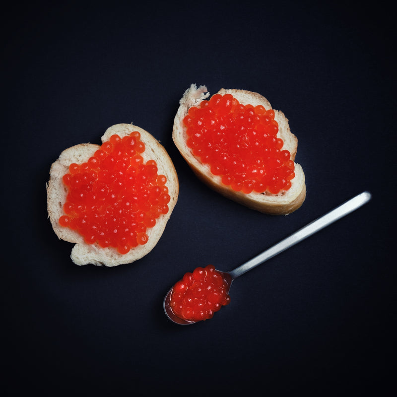 Step-by-step ikura sushi preparation with salmon roe, rice, and nori