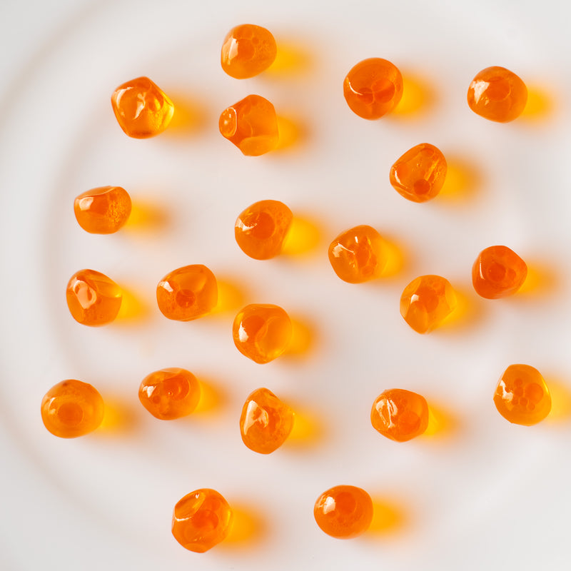 Assorted salmon roe varieties — chum, sockeye, and coho ikura — displayed in small glass bowls on a dark slate surface
