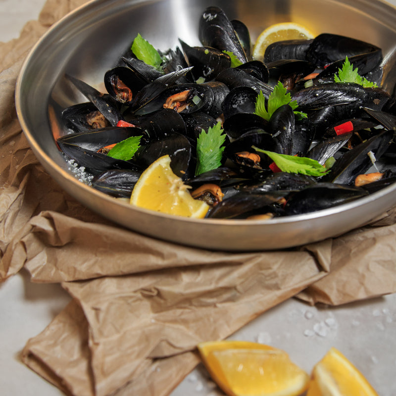 Spaghetti with steamed mussels in white wine garlic sauce, garnished with fresh parsley