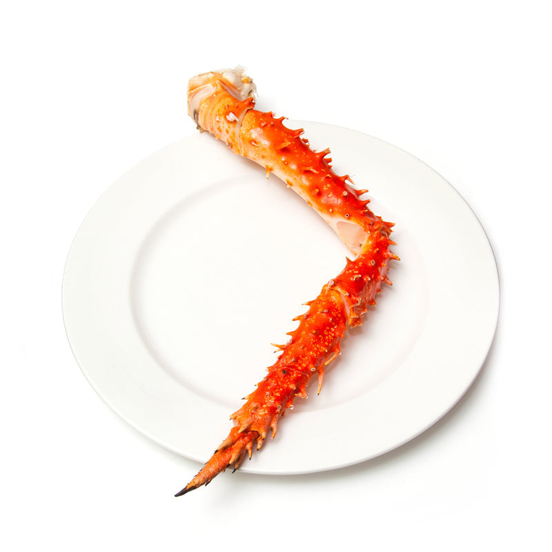 Assorted King Crab dishes including garlic butter crab legs, sushi rolls, and risotto served at a fine dining restaurant