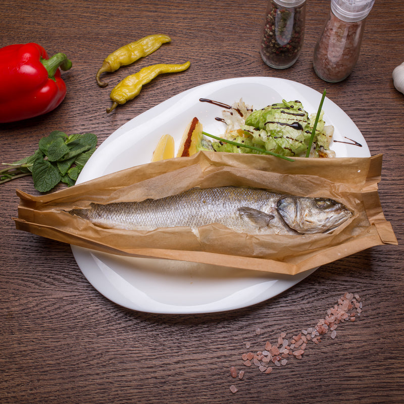 Fresh whole branzino (European sea bass) on ice at a fish market