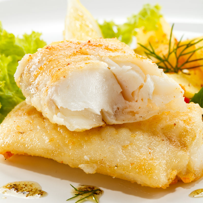 Elegantly plated lingcod fillet with roasted vegetables and herb sauce for a dinner party