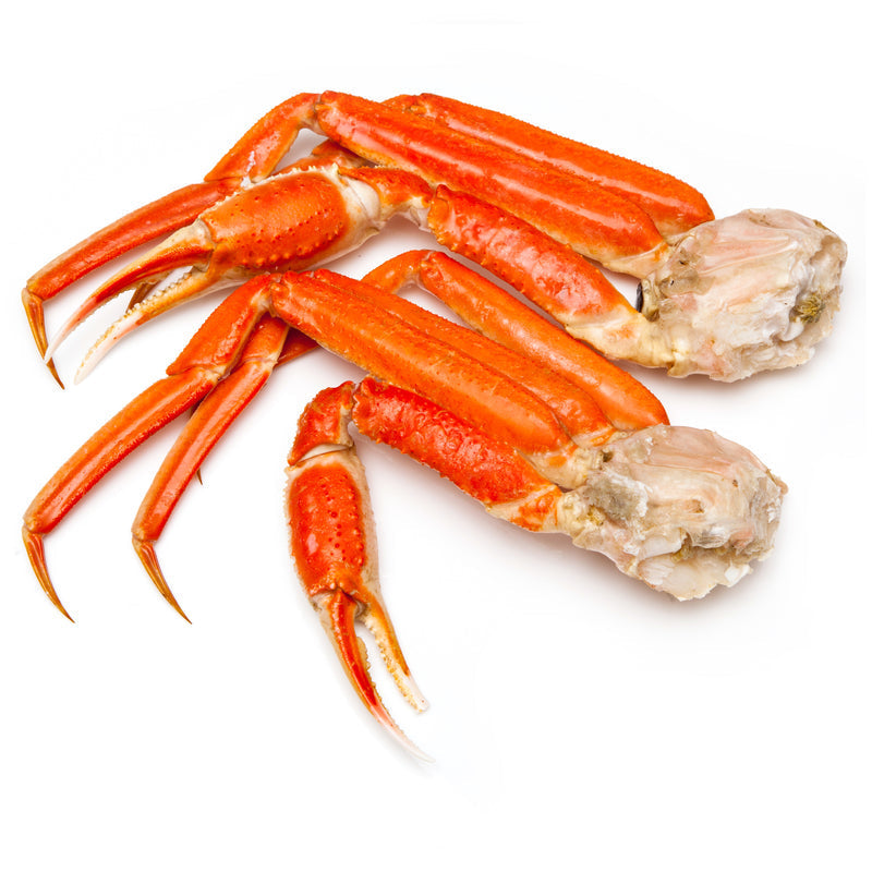 Cooked snow crab legs with melted butter and lemon wedges on a wooden serving board
