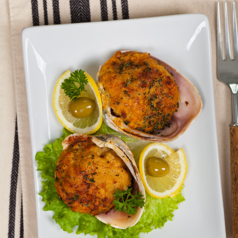 Golden-brown crab cakes on a plate with lemon wedges and tartar sauce, ready to freeze or serve