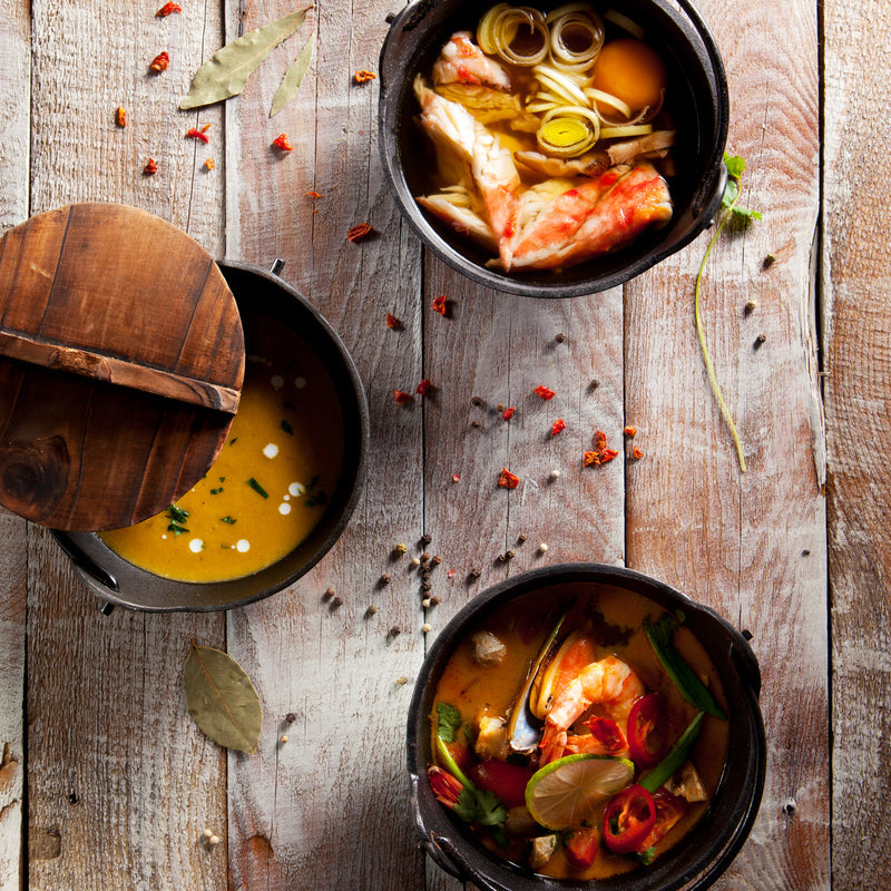 Steaming bowl of crab and shrimp stew with vegetables and fresh parsley garnish