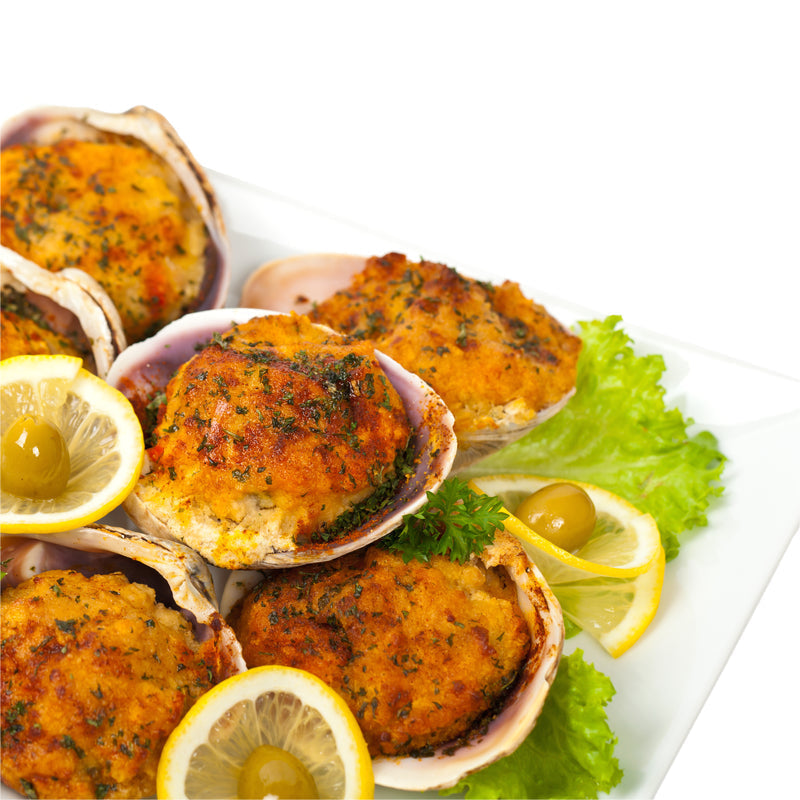 Golden-brown Dungeness crab cakes on a white plate garnished with lemon wedges and fresh cilantro