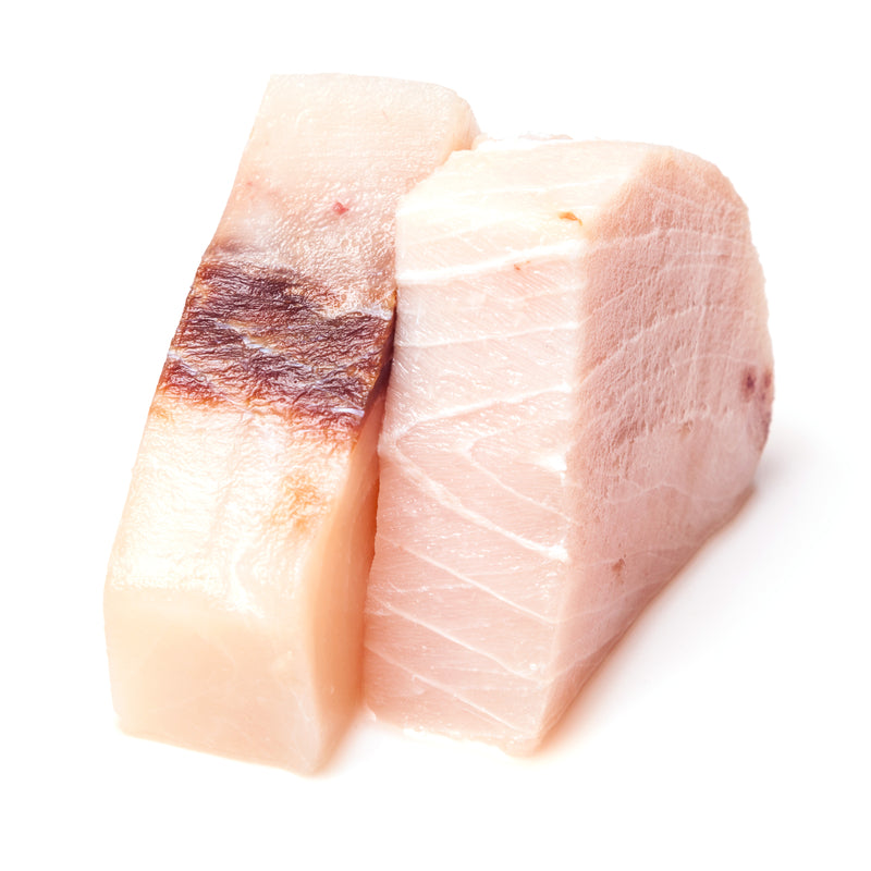Swordfish steak on the grill showing the firm, dense, meaty texture and light char — swordfish is one of the few fish that grills like a steak and appeals to people who don't typically enjoy fish