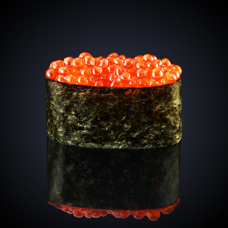 Ikura sushi gunkan maki with bright orange salmon roe on vinegared rice wrapped in nori, served on a wooden board
