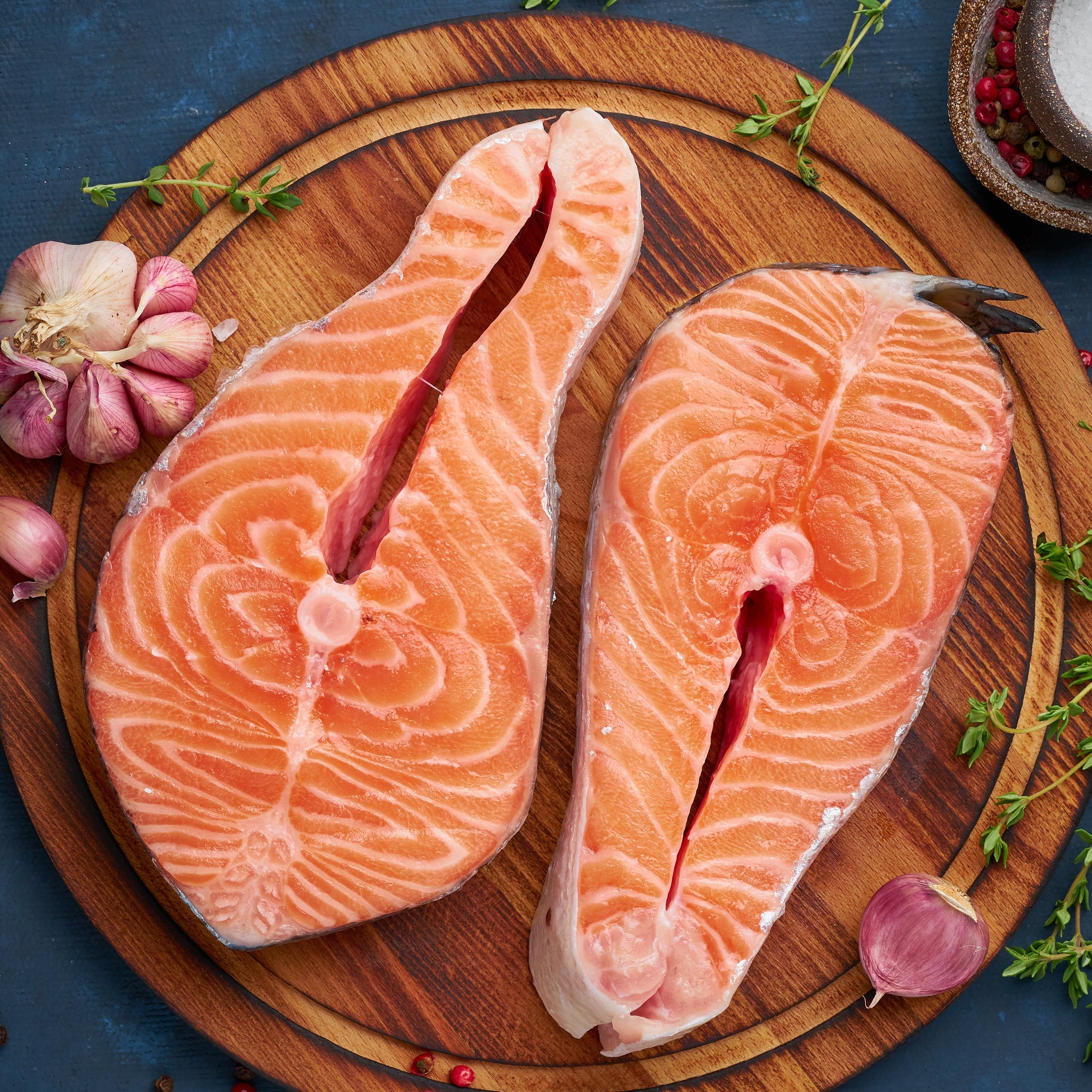 A beautifully cooked salmon steak, perfectly seared with golden edges, garnished with fresh herbs and lemon slices, served on a white plate for an elegant presentation