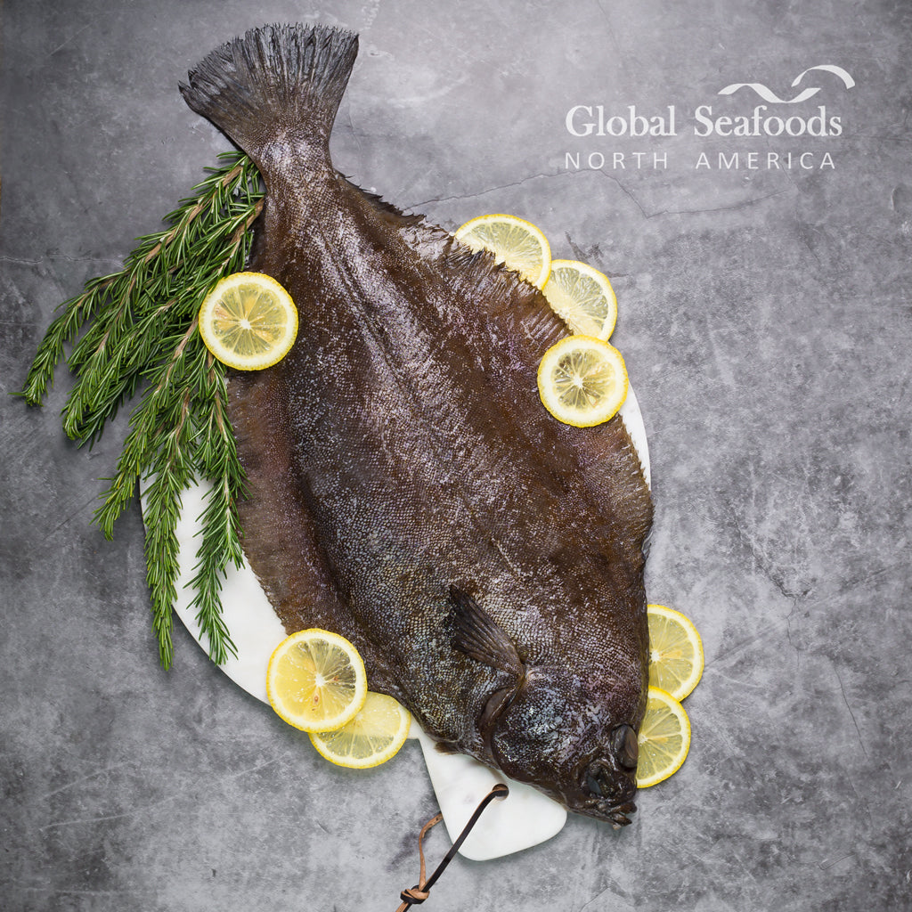 Whole flounder on a serving board with lemon slices