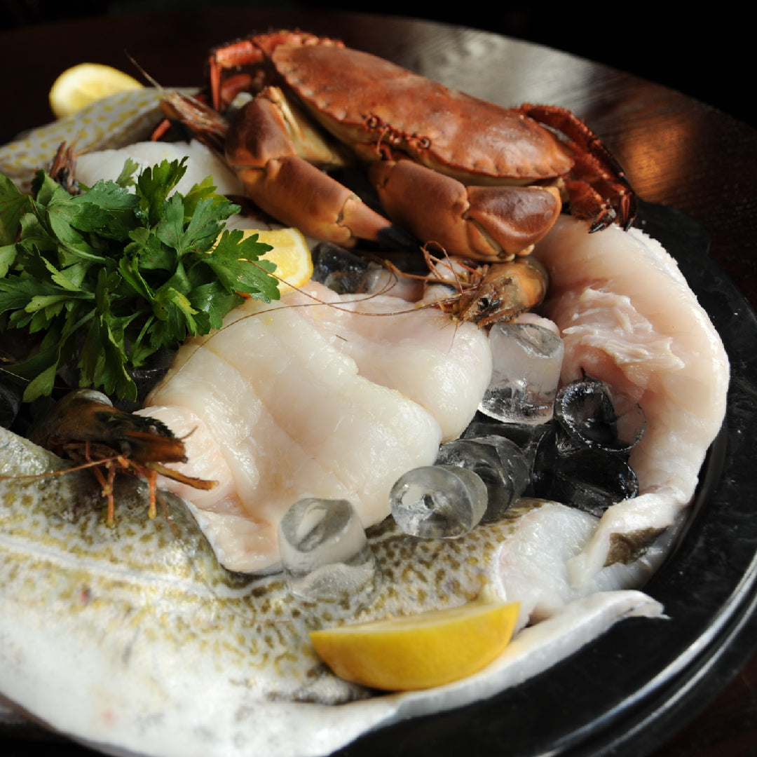 Gourmet seafood and cheese platter with shrimp, crab, brie, and goat cheese