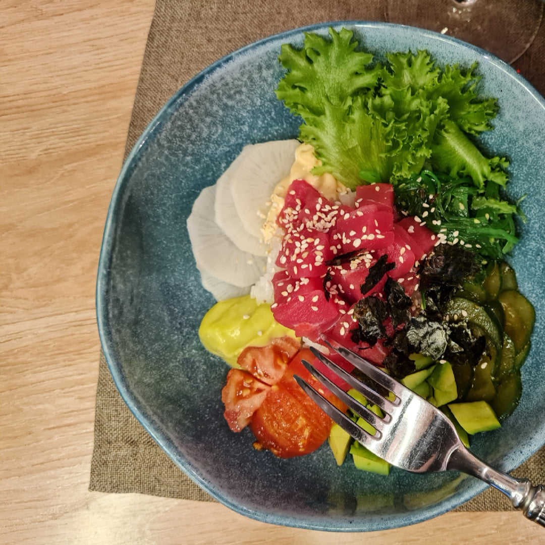 Five Bluefin tuna dishes arranged on a table: sashimi with ponzu, sesame-crusted steak, poke bowl, grilled tuna with herb butter, and spicy tartare