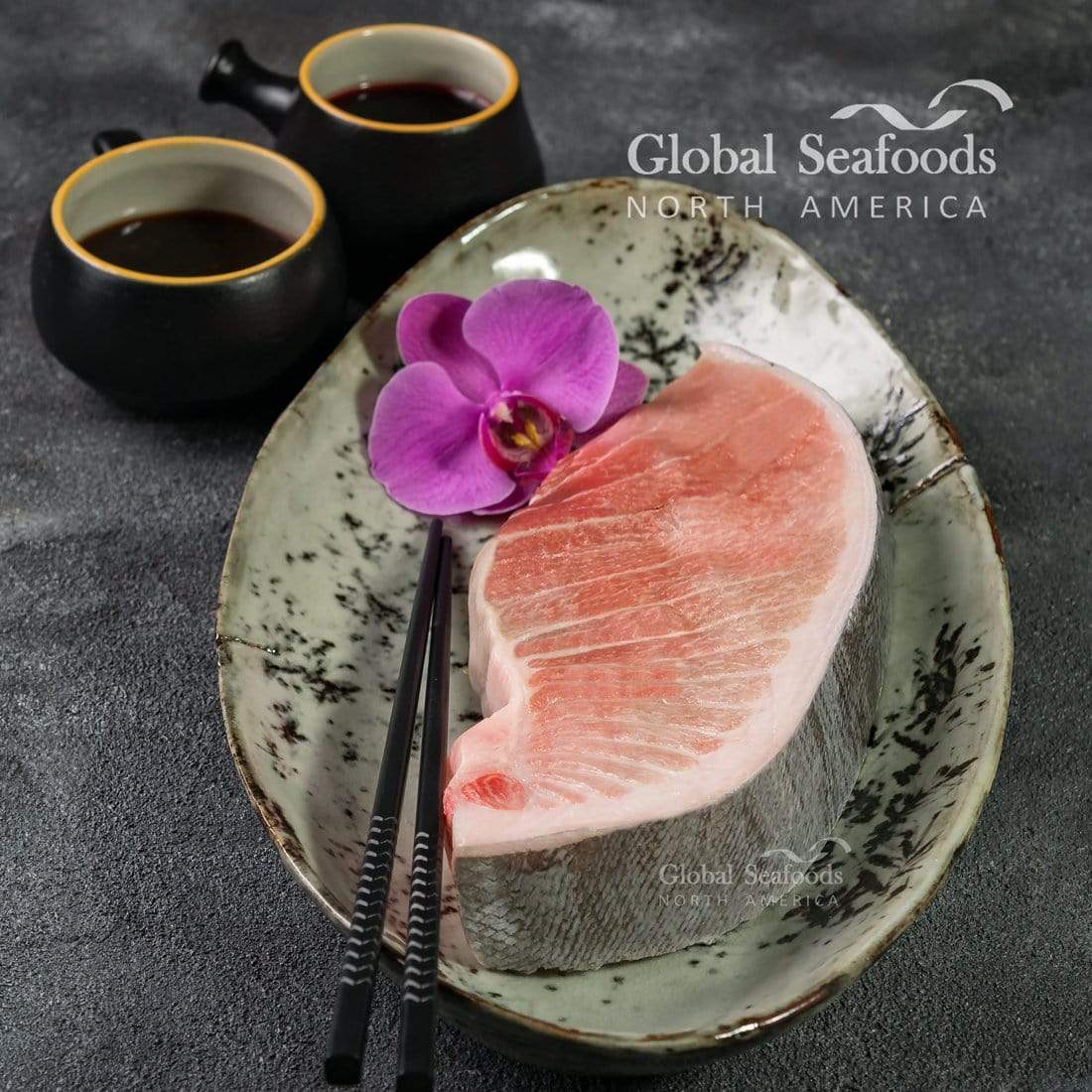 Seared Bluefin Toro slices with a lightly charred surface, garnished with microgreens and sesame seeds on a Japanese-style plate