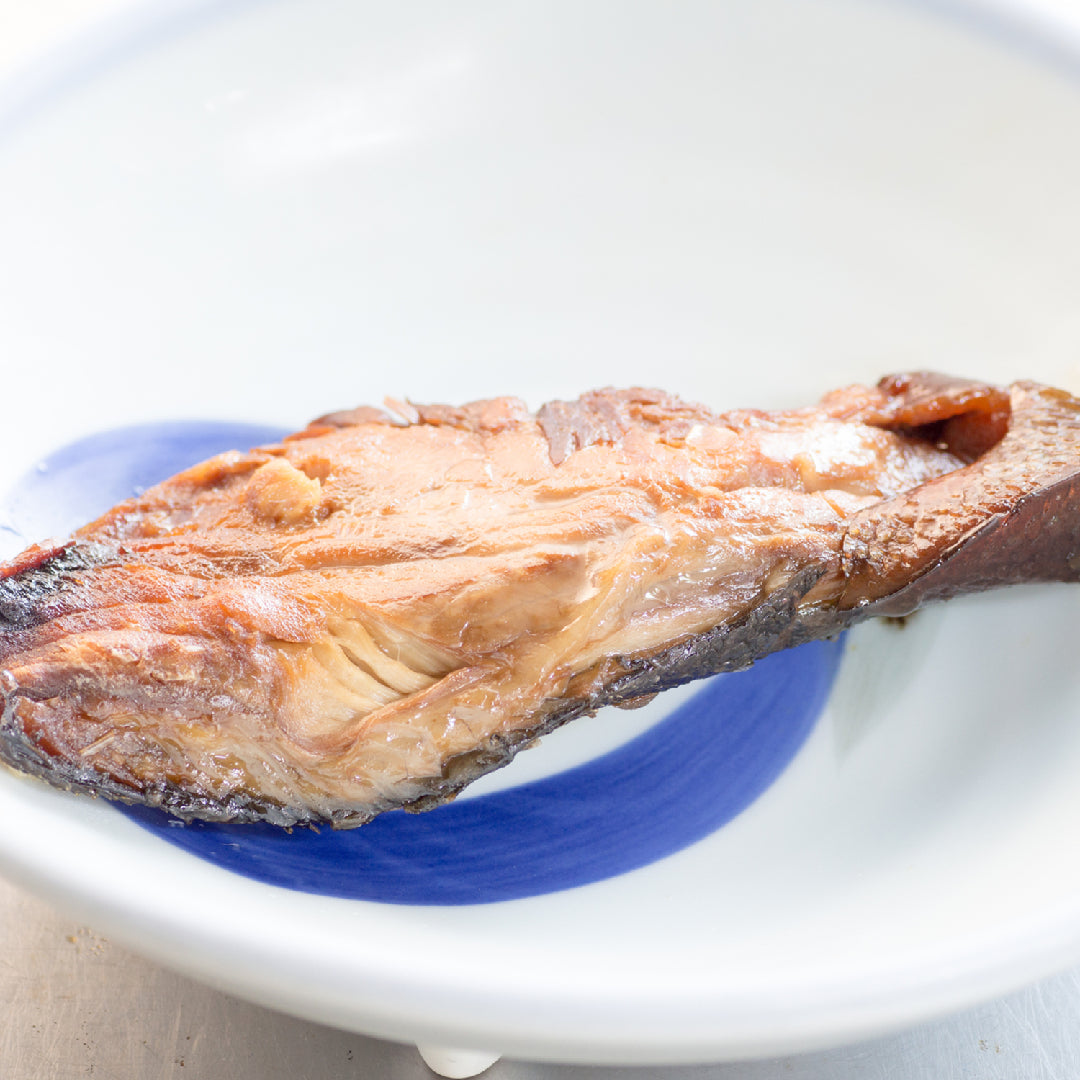 Fresh hamachi yellowtail fish fillet with vibrant pink flesh on a clean surface ready for sashimi