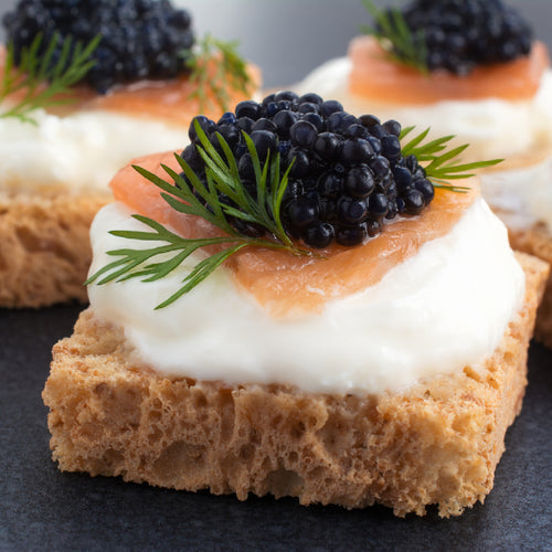 Hackleback caviar pearls in a small tin on crushed ice with a mother-of-pearl spoon