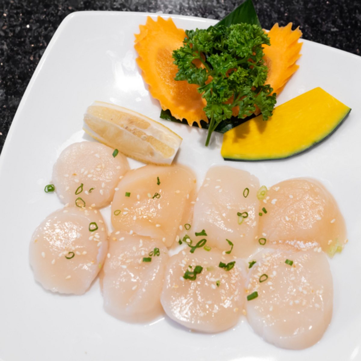 Thinly sliced Hokkaido scallop sashimi with wasabi, pickled ginger and soy sauce