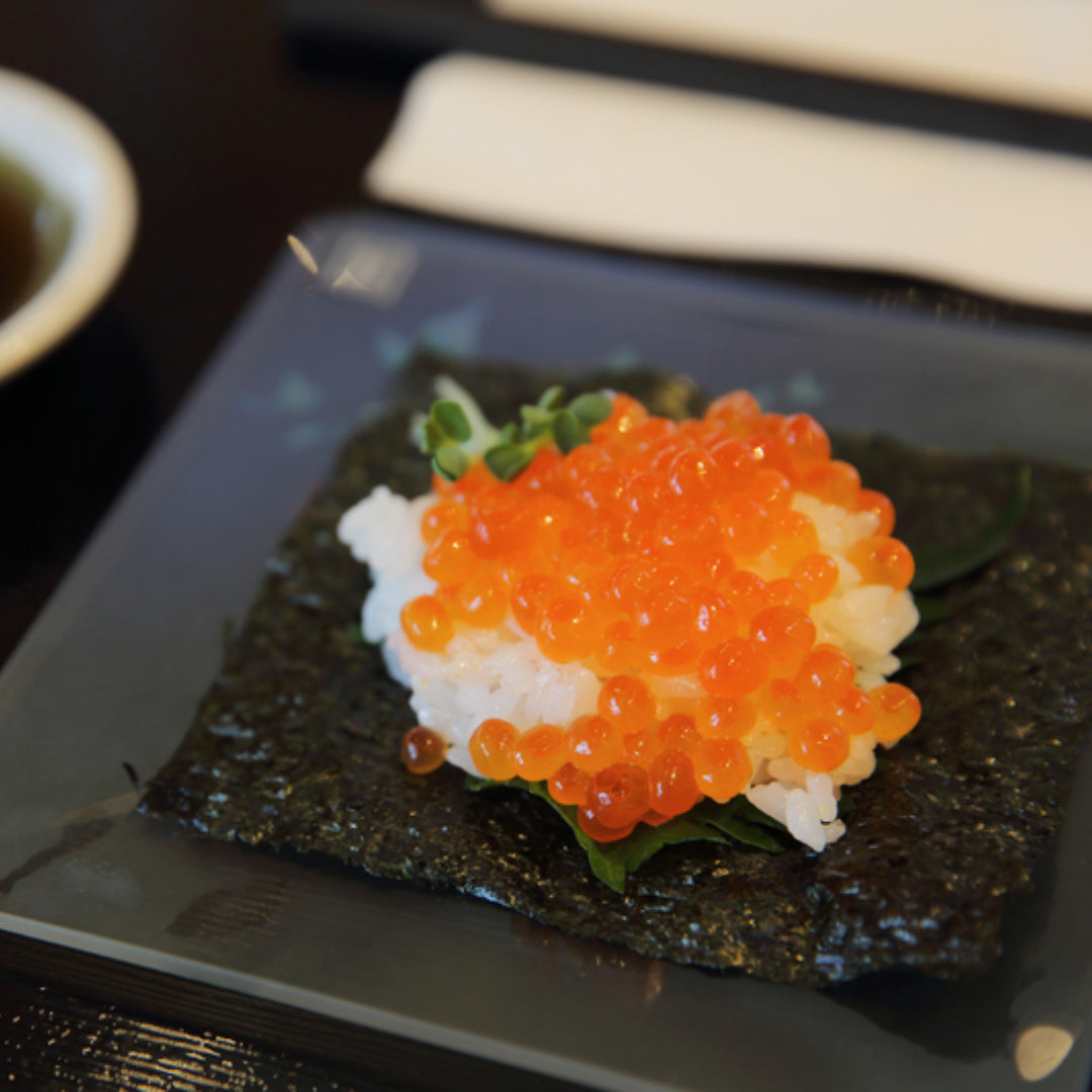 Ikura nigiri sushi – salmon roe on seasoned sushi rice wrapped with nori