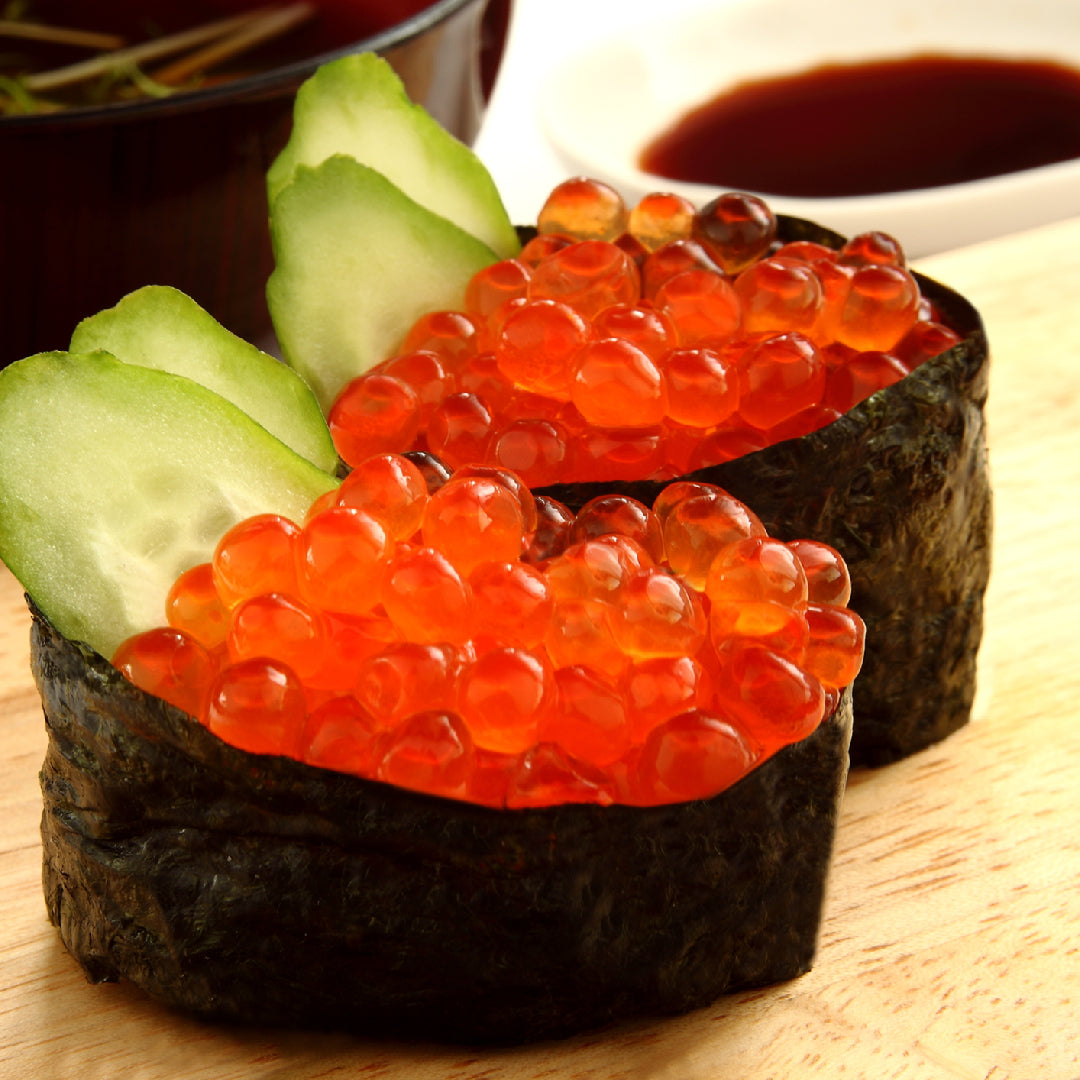 Ikura omelette on a white plate with bright orange salmon roe, fresh dill, and avocado slices, served with whole-grain toast
