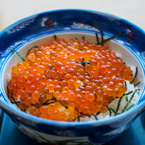 Bowl of vibrant, orange ikura (salmon roe), rich in nutrients and presented as a healthy, gourmet delicacy