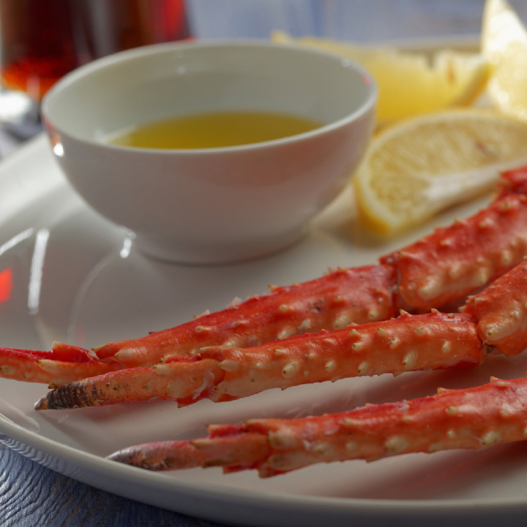 Assorted dipping sauces served alongside fresh king crab legs on a seafood platter